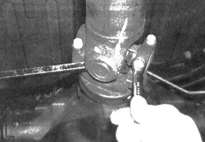 3.3. Чтобы заблокировать карданный вал при ослаблении затяжных болтов, проденьте большую отвертку…