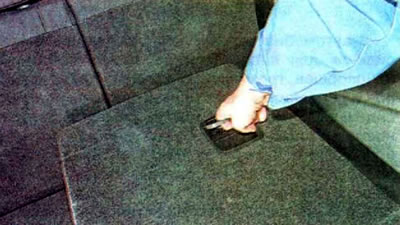 Тянем за фиксатор и поднимаем спинку правого сиденья вверх.