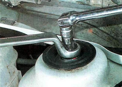 8. Ключом на 24 мм ослабляем гайку верхнего крепления амортизаторной стойки. При необходимости…