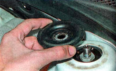 16. Окончательно отворачиваем верхнюю гайку крепления амортизаторной стойки и снимаем опорную шайбу.