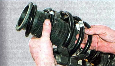 21. Аккуратно снимаем пружину со штока амортизатора (не снимая с нее стяжки).