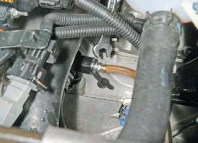 Folosind o cheie cu cap deschis de 10 mm, slăbiți niplul de purjare, ținând adaptorul pentru furtun…