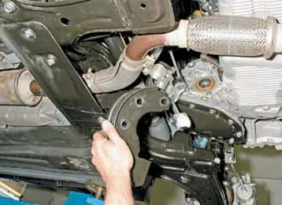 …folosind o cheie cu cap deschis de 17 mm, deșurubați cele trei șuruburi care fixează suportul de…