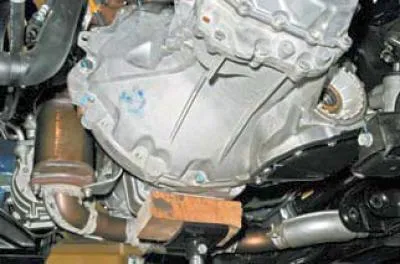 Din partea laterală a baii de ulei a motorului, folosiți un cap de 19 mm pentru a deșuruba cele…