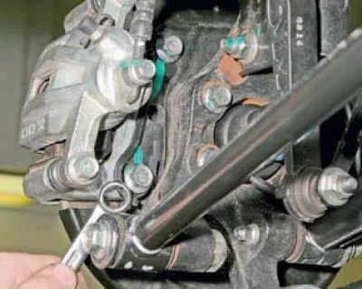 Demontujeme zadné koleso a bezpečne upevníme auto na továrensky vyrobený stojan.