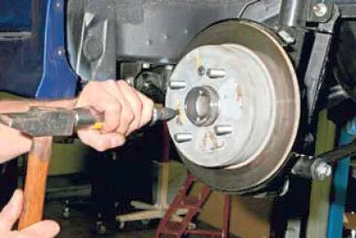 Pomocou kovovej kefy očistite špinu a koróziu z hlavy skrutky, ktorá upevňuje brzdový kotúč k…