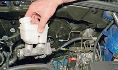 Folosind o priză de 13 mm, deșurubați cele două piulițe care fixează cilindrul de servofrâna..